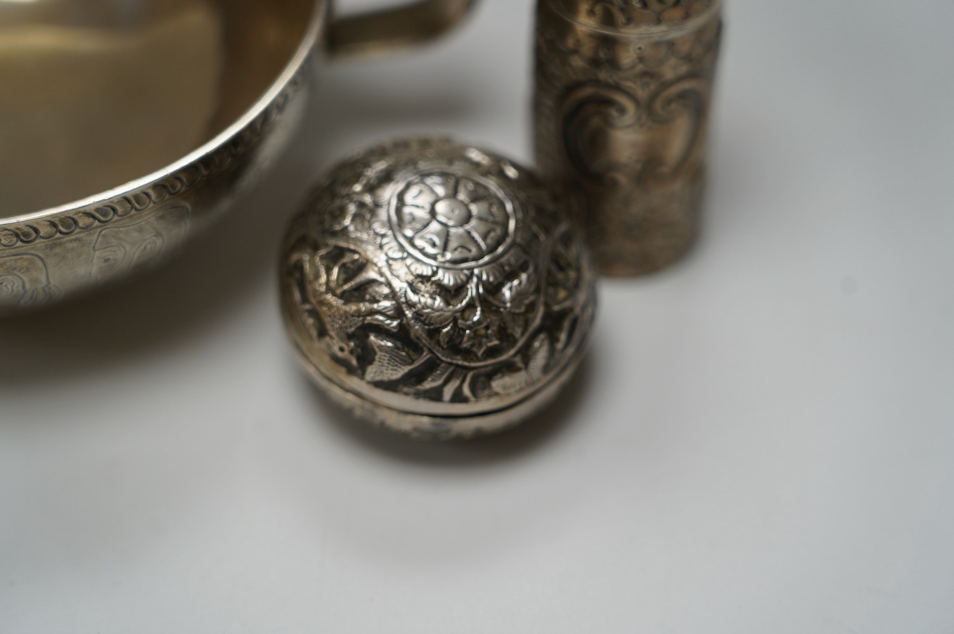 An Edwardian silver replica of a Mycenaean cup, Nathan & Hayes, Chester, 1912, height 62mm, together with a late Victorian silver mounted scent flask, two silver condiments and an Indian white metal box and cover. Condit